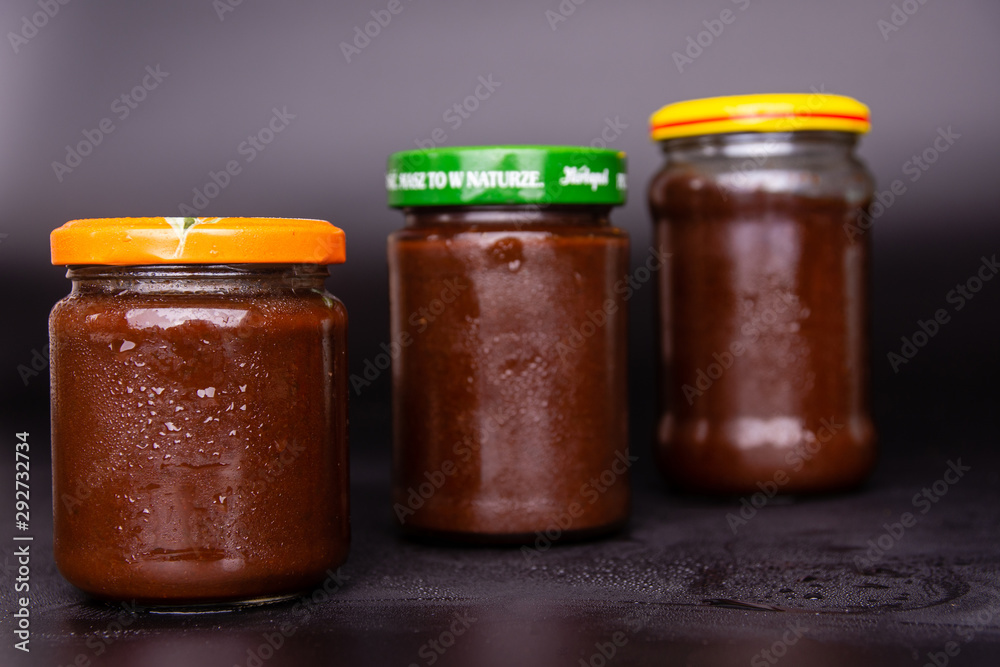 three jars of plum jam on a black background three jars of plum jam on a black background
