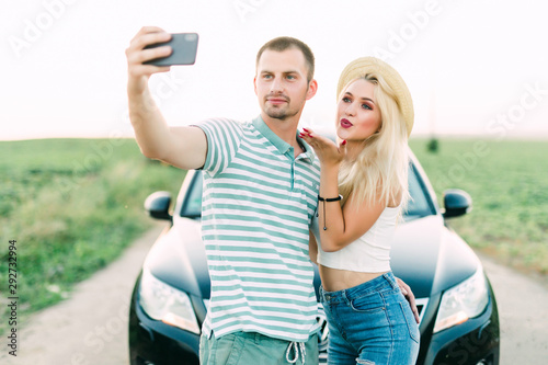Young happy in loved couple take selfie in front of their car