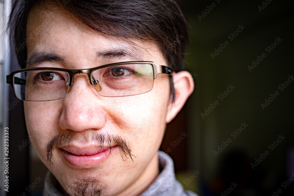 Close up face of Asian man with eyeglasses