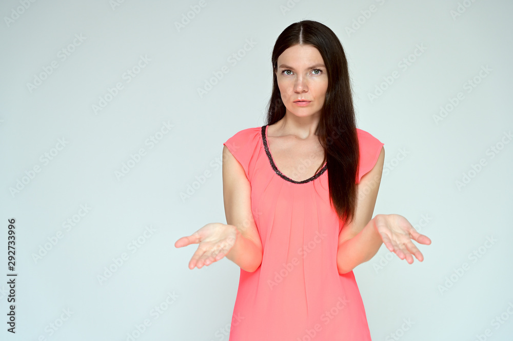 Portrait of a pretty young brunette woman with combed hair on a white background in a pink blouse. It is in different poses. Looks straight at the camera. Slim figure. Portrait of a pretty young brunette woman with combed hair on a white background in a pink blouse. It is in different poses. Looks straight at the camera. Slim figure.