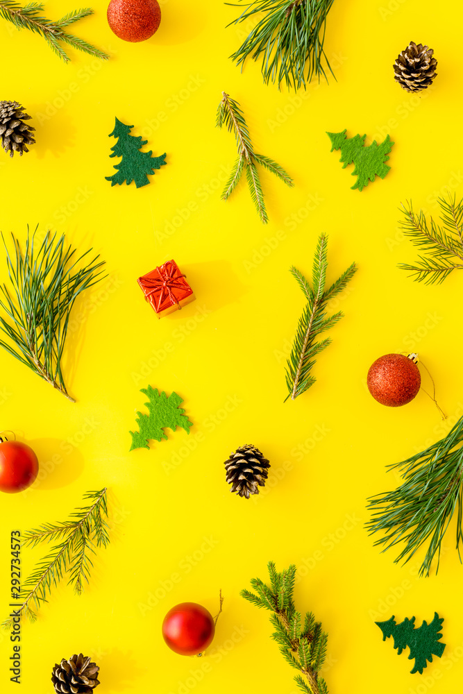 New Year background with fir branches and festive decoration on yellow table top view flat lay pattern