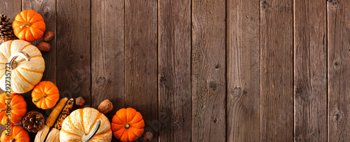 Autumn corner border banner of pumpkins and fall decor on a rustic wood background with copy space photo