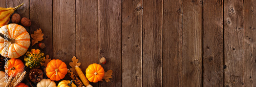 Autumn corner border banner of pumpkins, gourds and fall decor on a rustic wood background with copy space photo