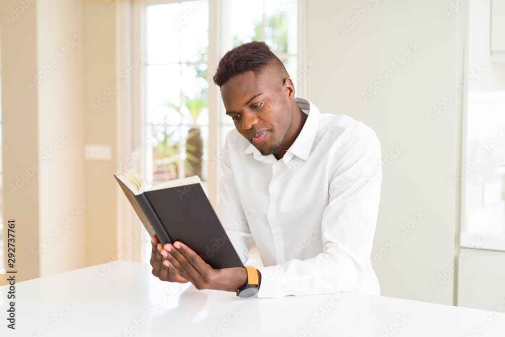 Young african man reading a book, studying for univeristy Young african man reading a book, studying for univeristy