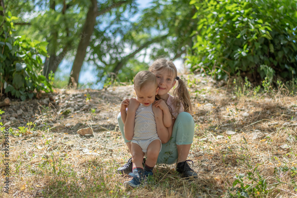 Sister hugs brother in the forest Sister hugs brother in the forest