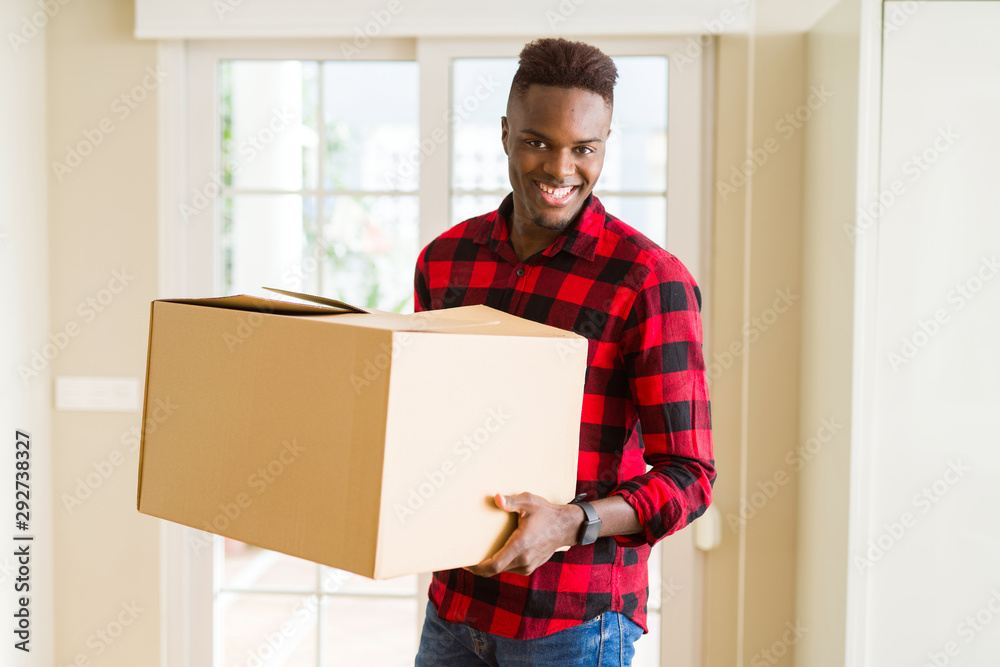 Young african american man holding a carton box, packing cardboard delivery package at home Young african american man holding a carton box, packing cardboard delivery package at home