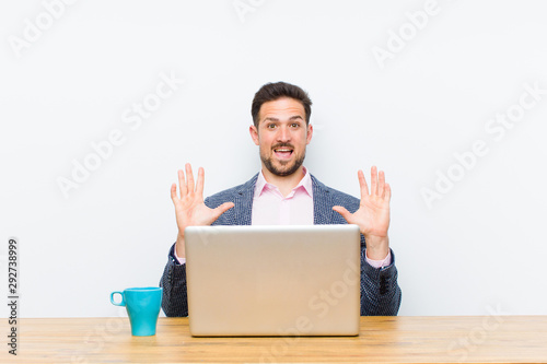 young handsome businessman feeling stupefied and scared, fearing something frightening, with hands open up front saying stay away photo