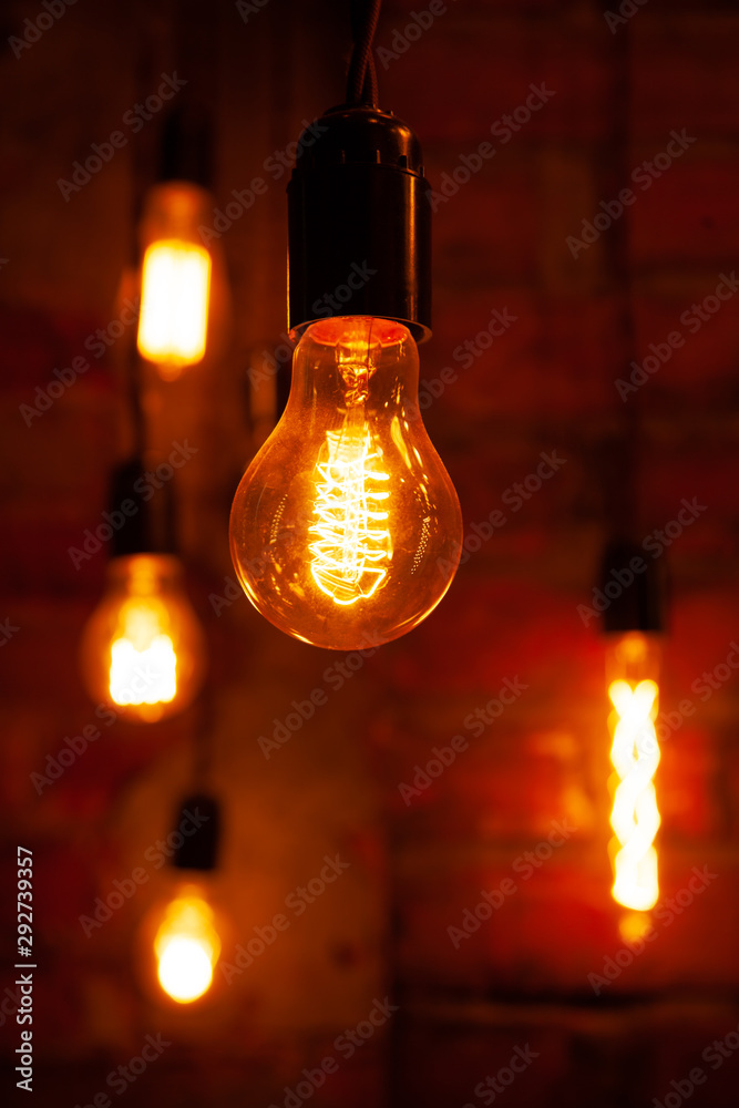 classic different retro light bulbs hanging on brick wall background at night classic different retro light bulbs hanging on brick wall background at night