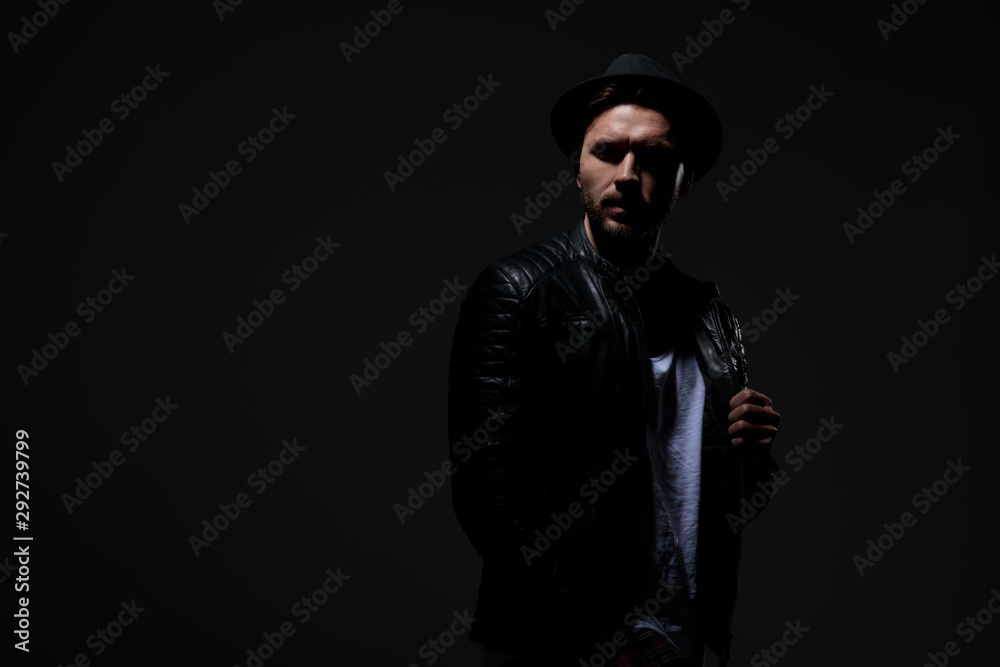 dramatic cool guy wearing leather jacket and hat