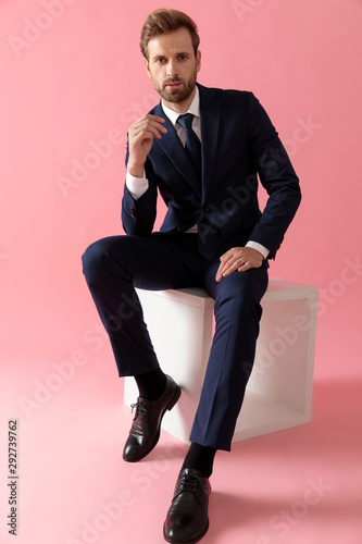 businessman sitting whit hands resting on laps looking at camera