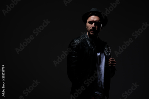 dramatic cool guy wearing leather jacket and hat