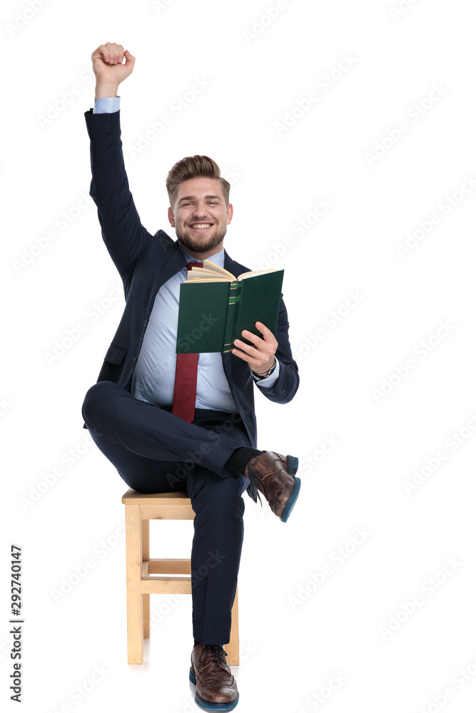 enthusiastic young businessman reading and holding arms up enthusiastic young businessman reading and holding arms up