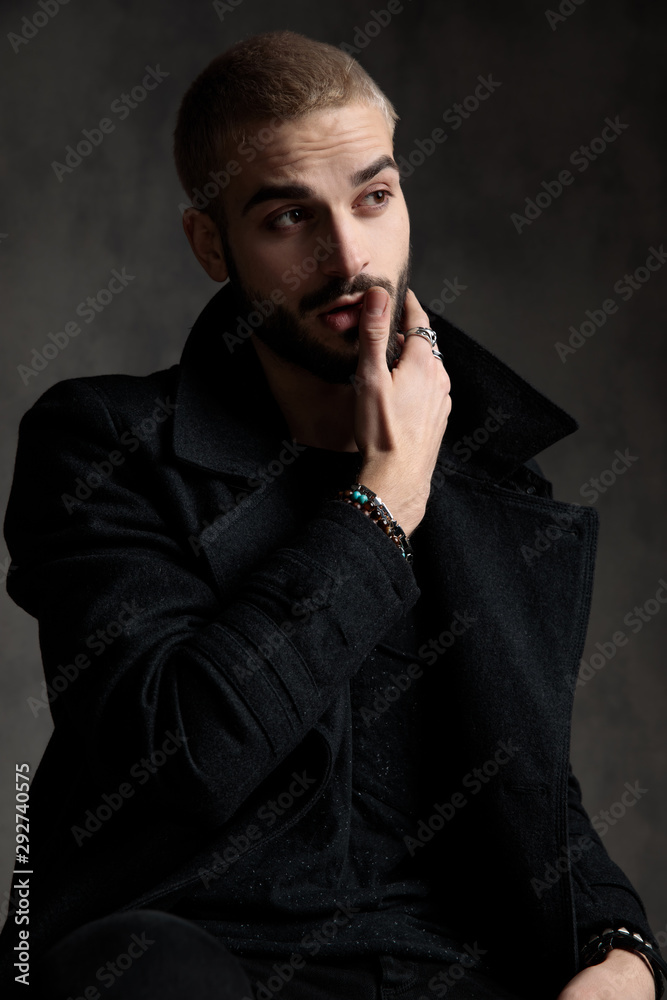 attractive fashion model wearing longcoat on grey background