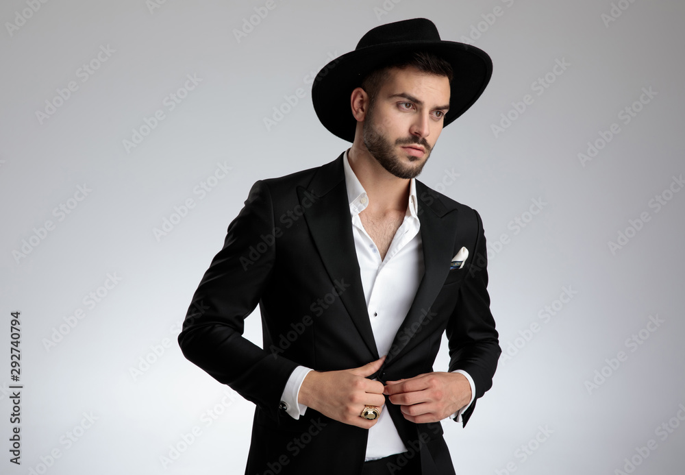 elegant attractive young man arranging coat on grey background elegant attractive young man arranging coat on grey background