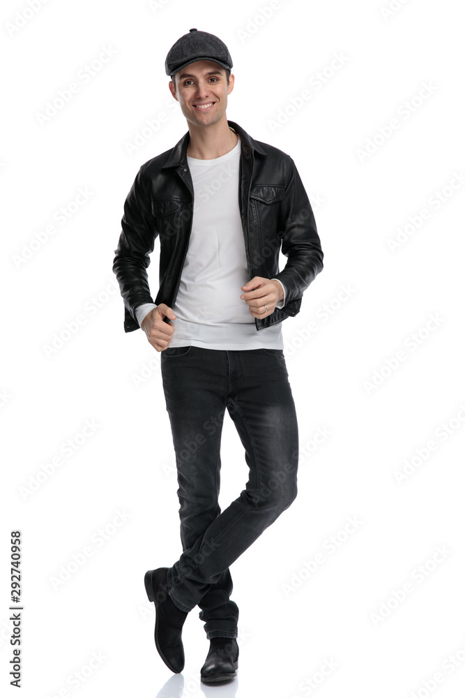 casual man standing with crossed legs fixing jacket happy casual man standing with crossed legs fixing jacket happy