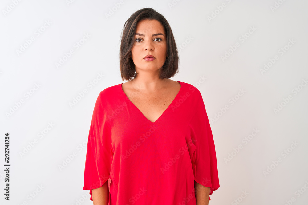 Fototapeta premium Young beautiful woman wearing red t-shirt standing over isolated white background with serious expression on face. Simple and natural looking at the camera.