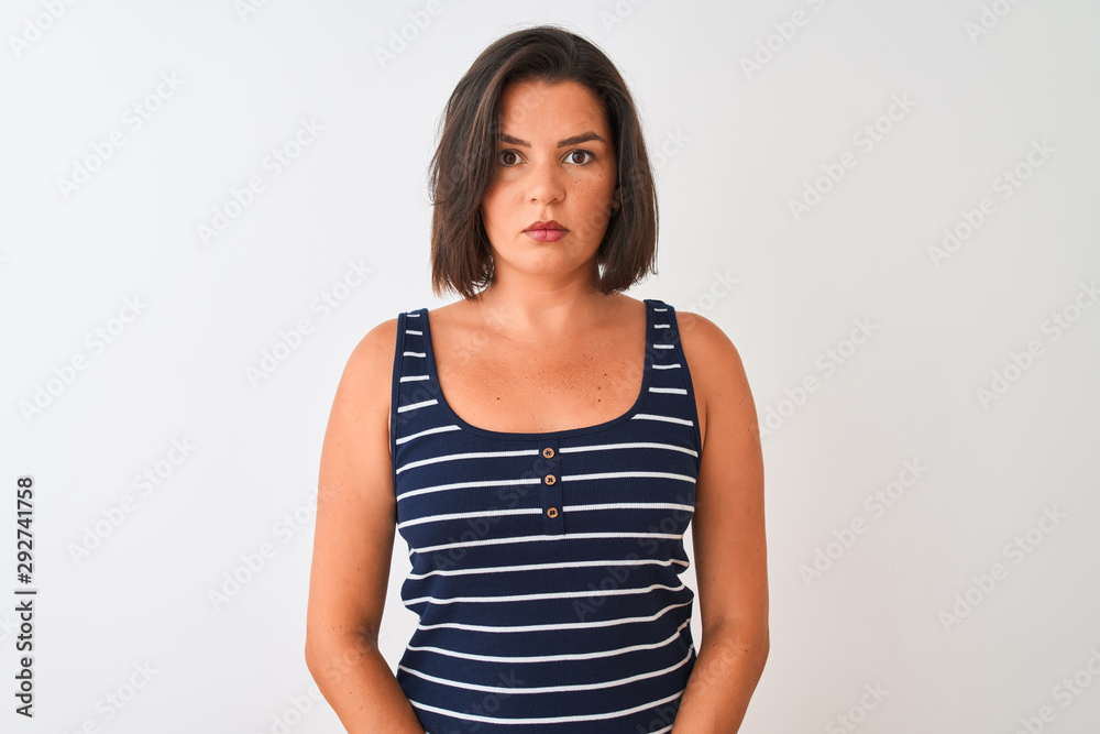 Young beautiful woman wearing blue striped t-shirt standing over isolated white background Relaxed with serious expression on face. Simple and natural looking at the camera. Young beautiful woman wearing blue striped t-shirt standing over isolated white background Relaxed with serious expression on face. Simple and natural looking at the camera.