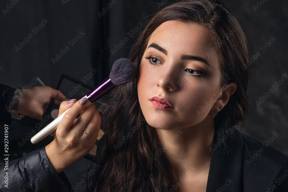 Obraz premium Makeup artist applies nude makeup to emphasize the natural beauty of the girls face