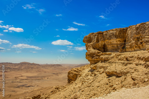 desert scenic background wallpaper view of high rock cliff above valley on vivid blue sky background, copy space