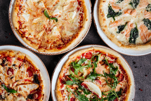 Traditional Italian pizza on a dark background top view copy space.