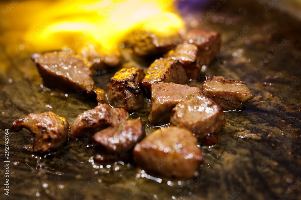 cooking beef steak on fire flaming barbecue in hot black pan cooking beef steak on fire flaming barbecue in hot black pan
