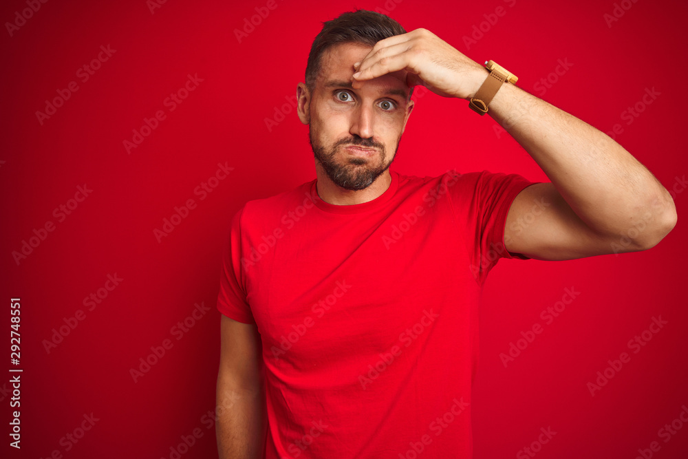Young handsome man wearing casual t-shirt over red isolated background worried and stressed about a problem with hand on forehead, nervous and anxious for crisis Young handsome man wearing casual t-shirt over red isolated background worried and stressed about a problem with hand on forehead, nervous and anxious for crisis