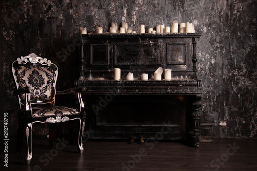 old black vintage piano with white candles and retro chair. nobody