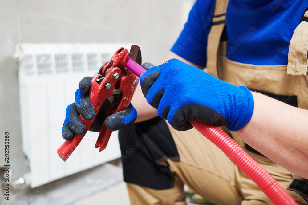 plumber at work. Installing water heating radiator plumber at work. Installing water heating radiator