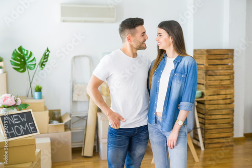 Beautiful young couple moving to a new house, smiling happy arround cardboard boxes © Krakenimages.com