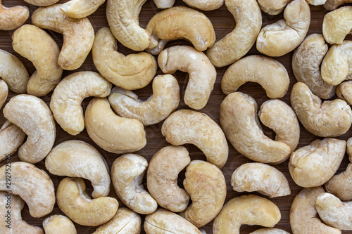 Background in the form of cashew nuts on a brown wooden surface