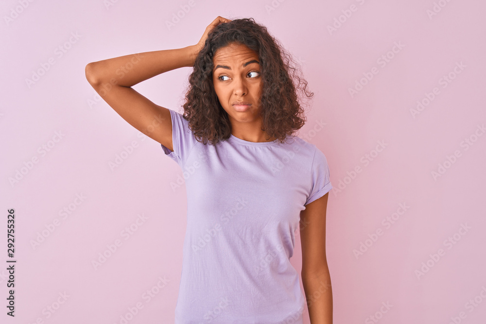 Young brazilian woman wearing t-shirt standing over isolated pink background confuse and wondering about question. Uncertain with doubt, thinking with hand on head. Pensive concept. Young brazilian woman wearing t-shirt standing over isolated pink background confuse and wondering about question. Uncertain with doubt, thinking with hand on head. Pensive concept.