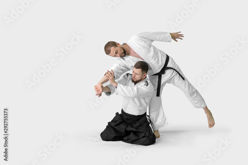 Two caucasian men are practicing aikido on the tatami (isolation path included) photo
