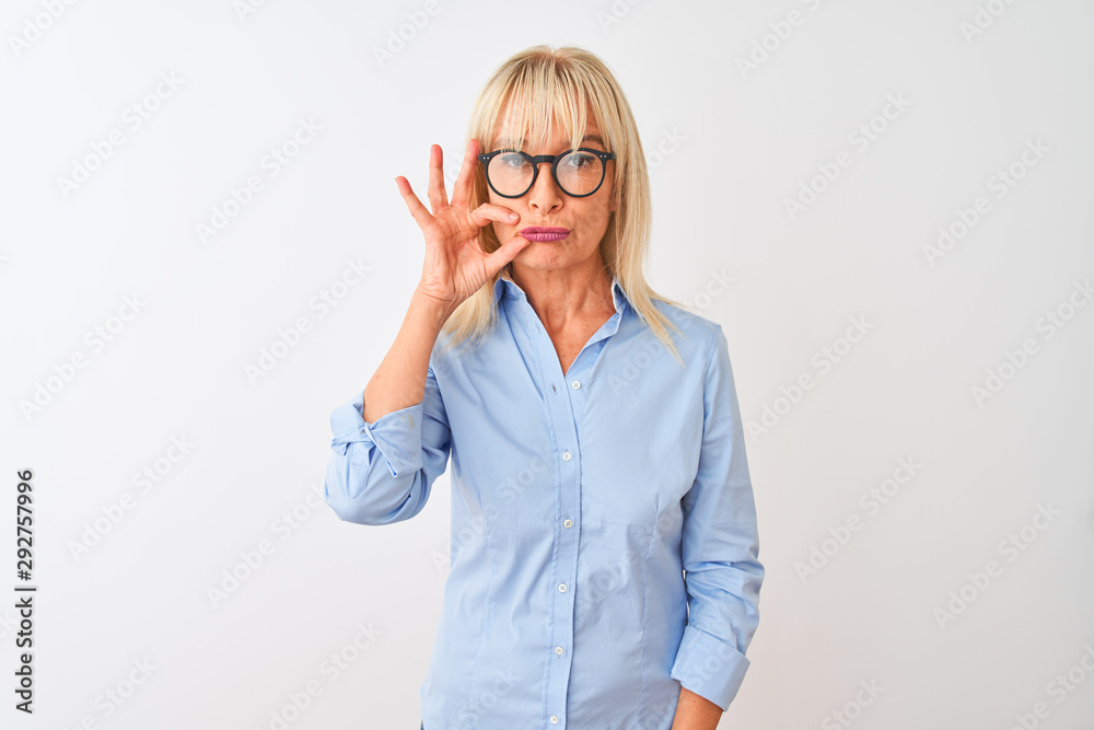Middle age businesswoman wearing elegant shirt and glasses over isolated white background mouth and lips shut as zip with fingers. Secret and silent, taboo talking
