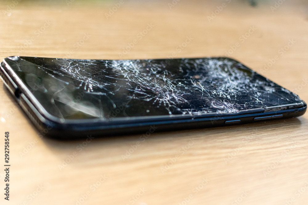Broken screen cell phone on light background. Old broken black smartphone  on the table. Close up photos showing process of mobile phone repair.  Smartphone and wooden hummer. Stock Photo | Adobe Stock