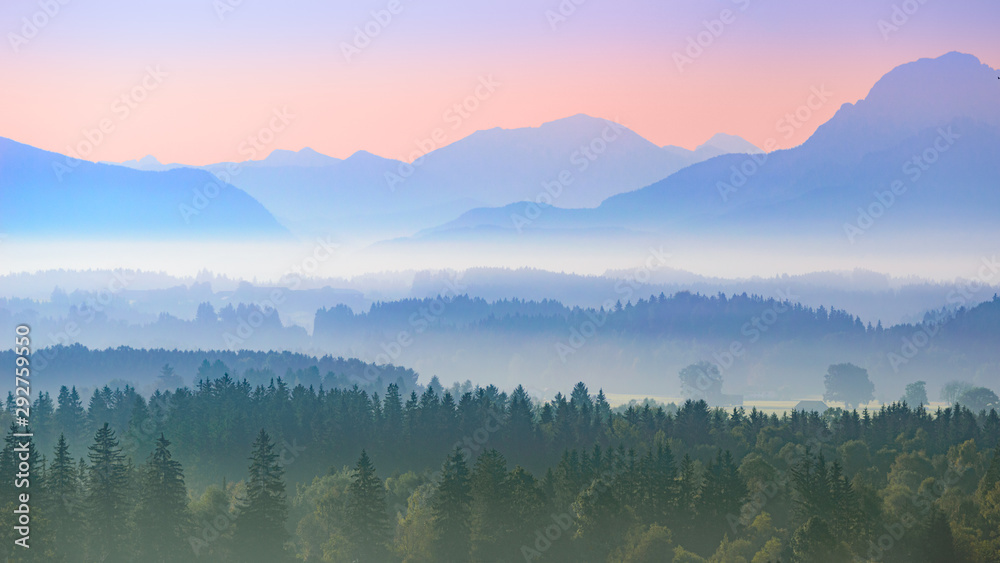 Aerial panoramic landscape of Alpine foggy foothills with morning sunrise over mountains Aerial panoramic landscape of Alpine foggy foothills with morning sunrise over mountains