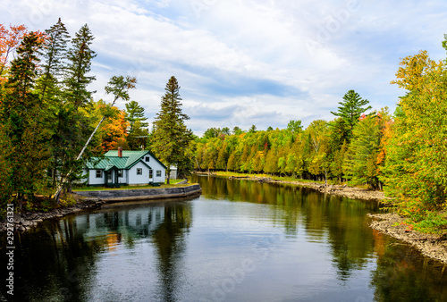 Beautiful House and Reflection on a River in the State of Maine with Fall Autumn Colored Trees all Around it