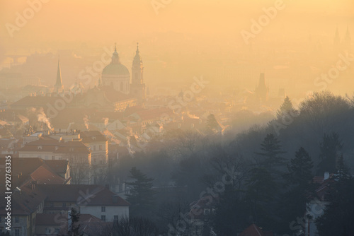 Winter morning in the Mala Strana district - historical part of Prague, Czech Republic. St. Nicholas Church. Sunrise. Fog. View from the Strahov Monastery.