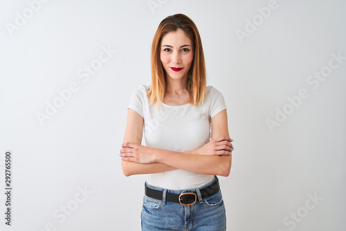 Beautiful redhead woman wearing casual t-shirt standing over isolated white background happy face smiling with crossed arms looking at the camera. Positive person.