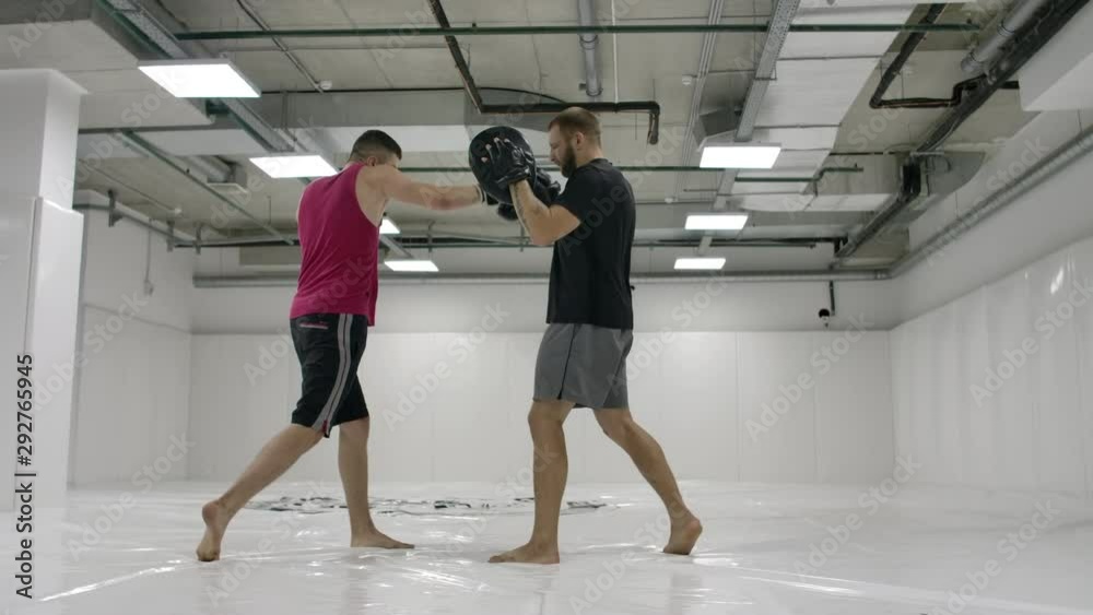 Male fighter boxer with coaches practicing the technique of blows and dodging blows in slow motion. Preparation for the fight with the coach. Professional fighter. Male fighter boxer with coaches practicing the technique of blows and dodging blows in slow motion. Preparation for the fight with the coach. Professional fighter.