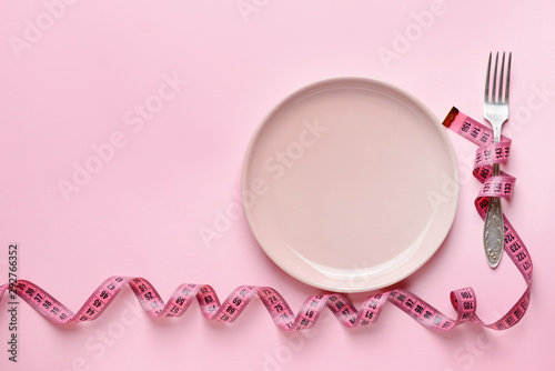Fork with plate and measuring tape on color background. Concept of diet