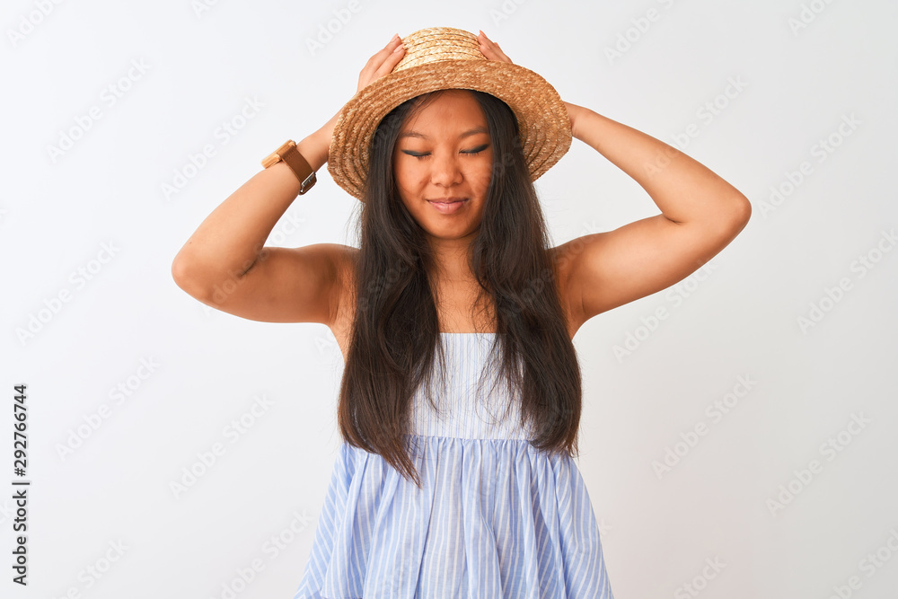 Young chinese woman wearing striped dress and hat standing over isolated white background suffering from headache desperate and stressed because pain and migraine. Hands on head. Young chinese woman wearing striped dress and hat standing over isolated white background suffering from headache desperate and stressed because pain and migraine. Hands on head.