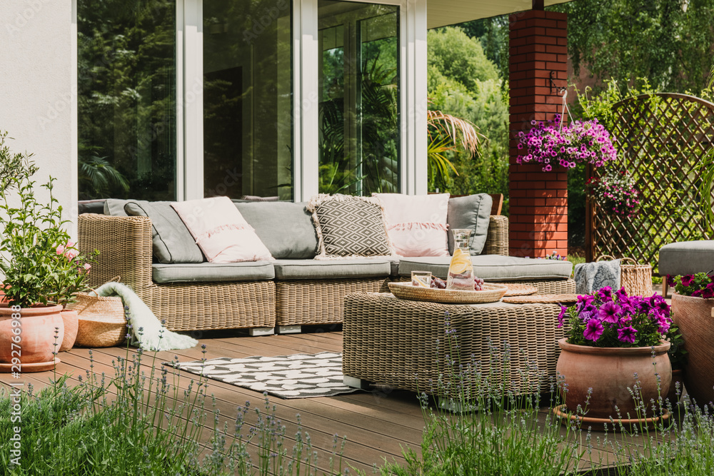 Classy furniture on wooden terrace in green beautiful garden - obrazy, fototapety, plakaty 