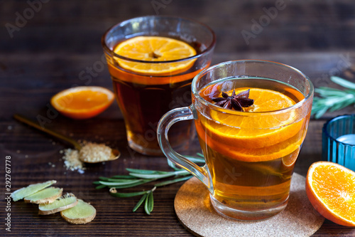 Hot citrus tea on wood table, close-up. Healthy warming drinks with lemon orange and honey.