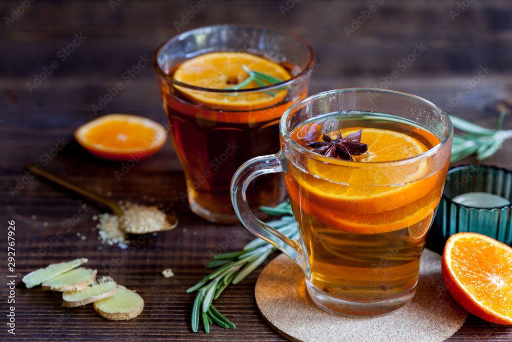 Two glasses with hot citrus tea on dark wood table, close-up Two glasses with hot citrus tea on dark wood table, close-up
