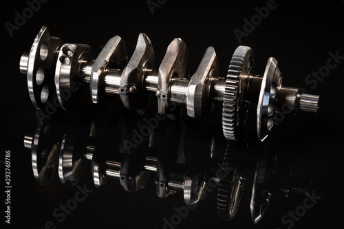 high performance racing motorcycle crankshaft on a reflective black background. lit with a flash for different affects. photo