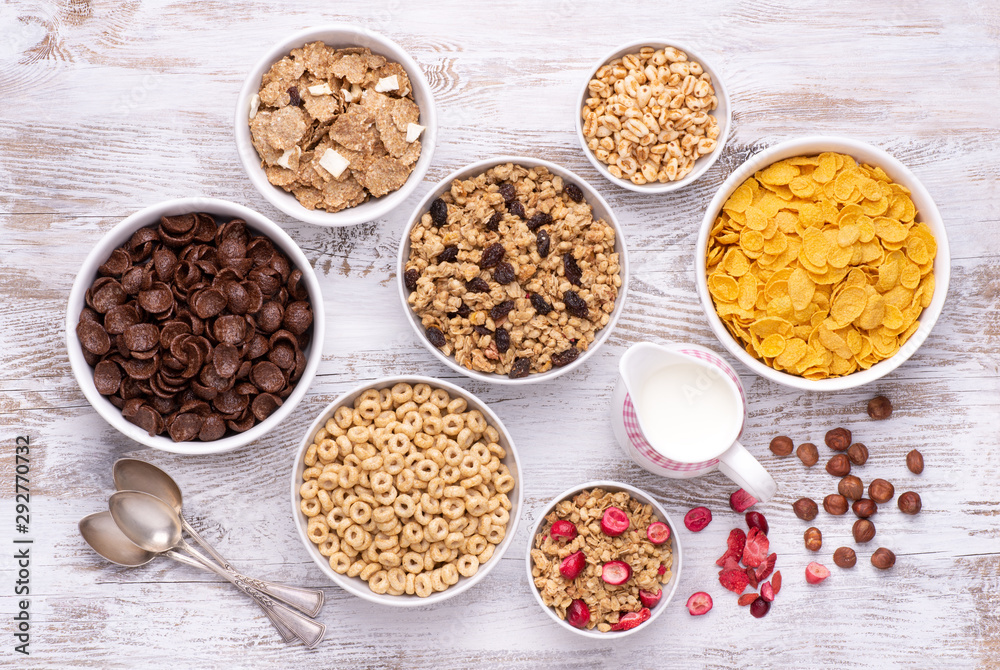 Breakfast cereals in white bowls on white wooden table, top view Breakfast cereals in white bowls on white wooden table, top view