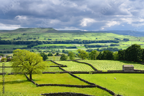 Askrigg village from Cross Top road in Wensleydale River Ure valley in dappled sun North Yorkshire England photo