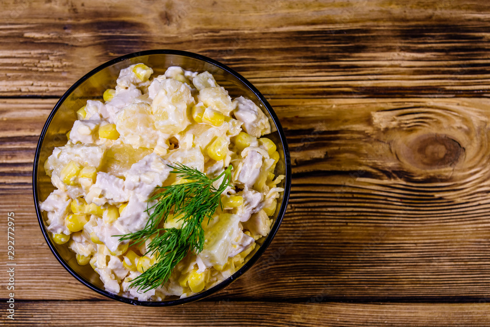 Festive salad with chicken breast, canned pineapple, cheese, sweet corn and mayonnaise on wooden table. Top view Festive salad with chicken breast, canned pineapple, cheese, sweet corn and mayonnaise on wooden table. Top view