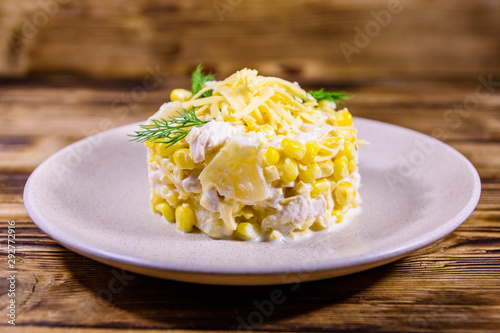 Festive salad with chicken breast, canned pineapple, cheese, sweet corn and mayonnaise on wooden table