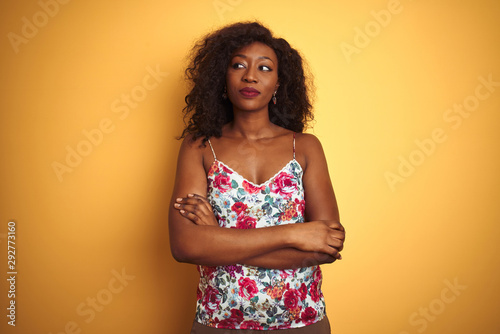 African american woman wearing floral summer t-shirt over isolated yellow background smiling looking to the side and staring away thinking.